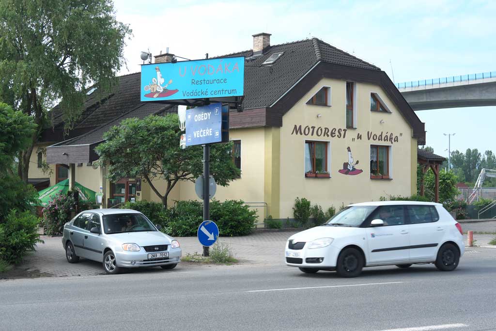 Budova motorestu U vodáka s vodáckou cedulí v Radotíně