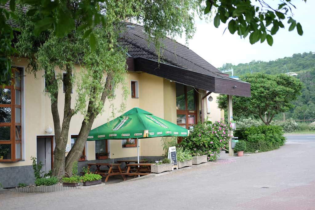 Motorest U vodáka u řeky s posezením ve stínu stromů