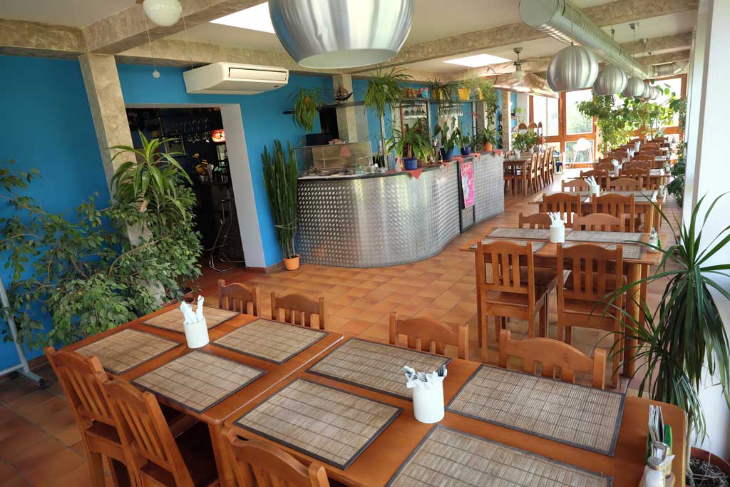 Interiér restaurace s barem a modrou stěnou